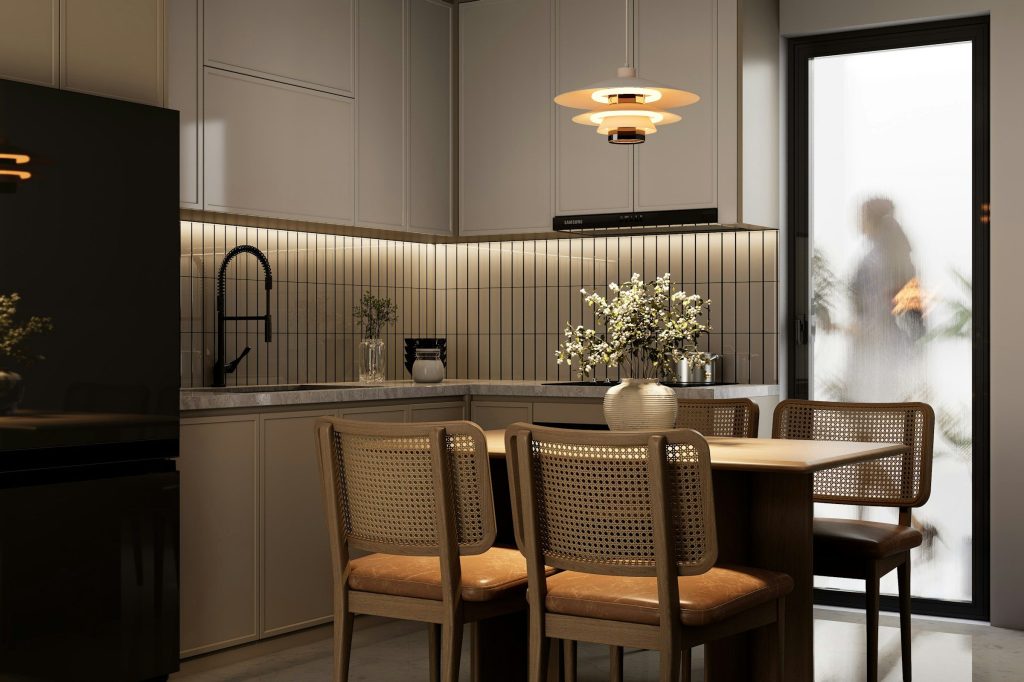 A warm kitchen with cane chairs, a tiled splashback and a pendant over the table